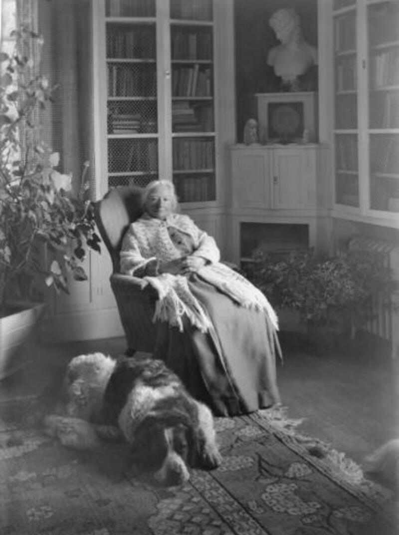 Ellen Key med hunden Gullan i biblioteket 